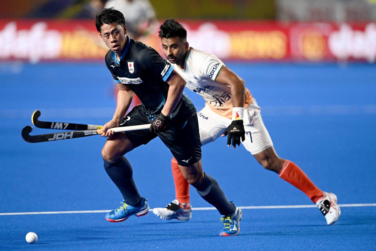Japan’s Yamashita Manabu (L) runs with the ball under pressure from India’s Singh Manpreet (R) during the Asian Champions Trophy 2023 