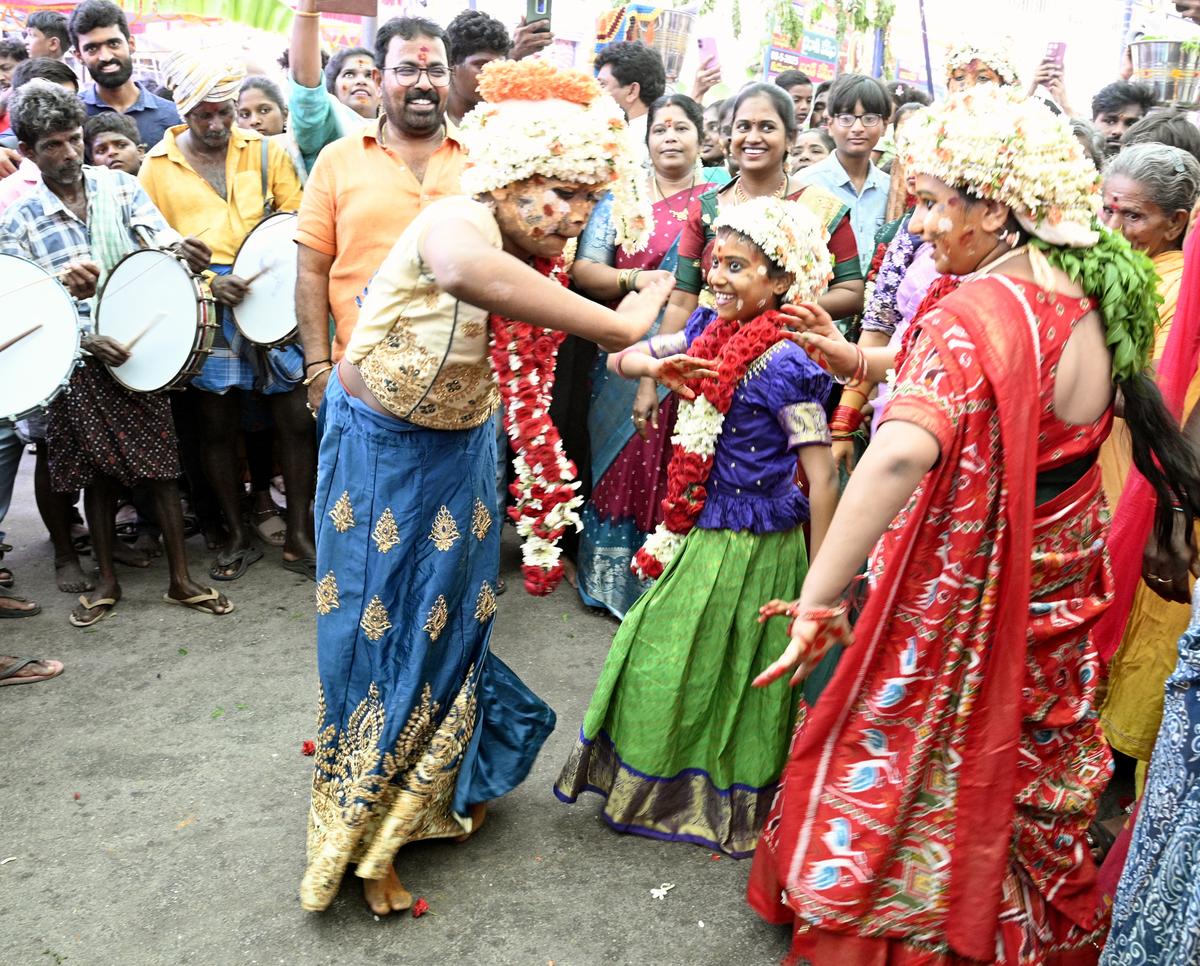 Visitors wearing a crown of flowers dance to the rhythm of the drums during the ongoing Gangamma Jatara in Tirupati. 
