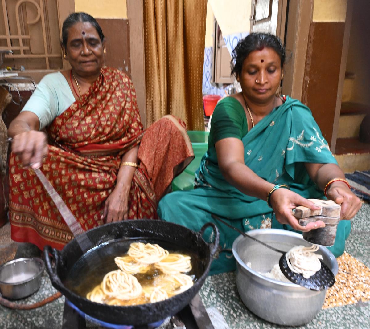 Lakshmi, fondly called ‘Murukkukaraamma’, fries batches of murukku with help from one of her family members in Madurai. Lakshmi, fondly called ‘Murukkukaraamma’, fries batches of murukku with help from one of her family members in Madurai.