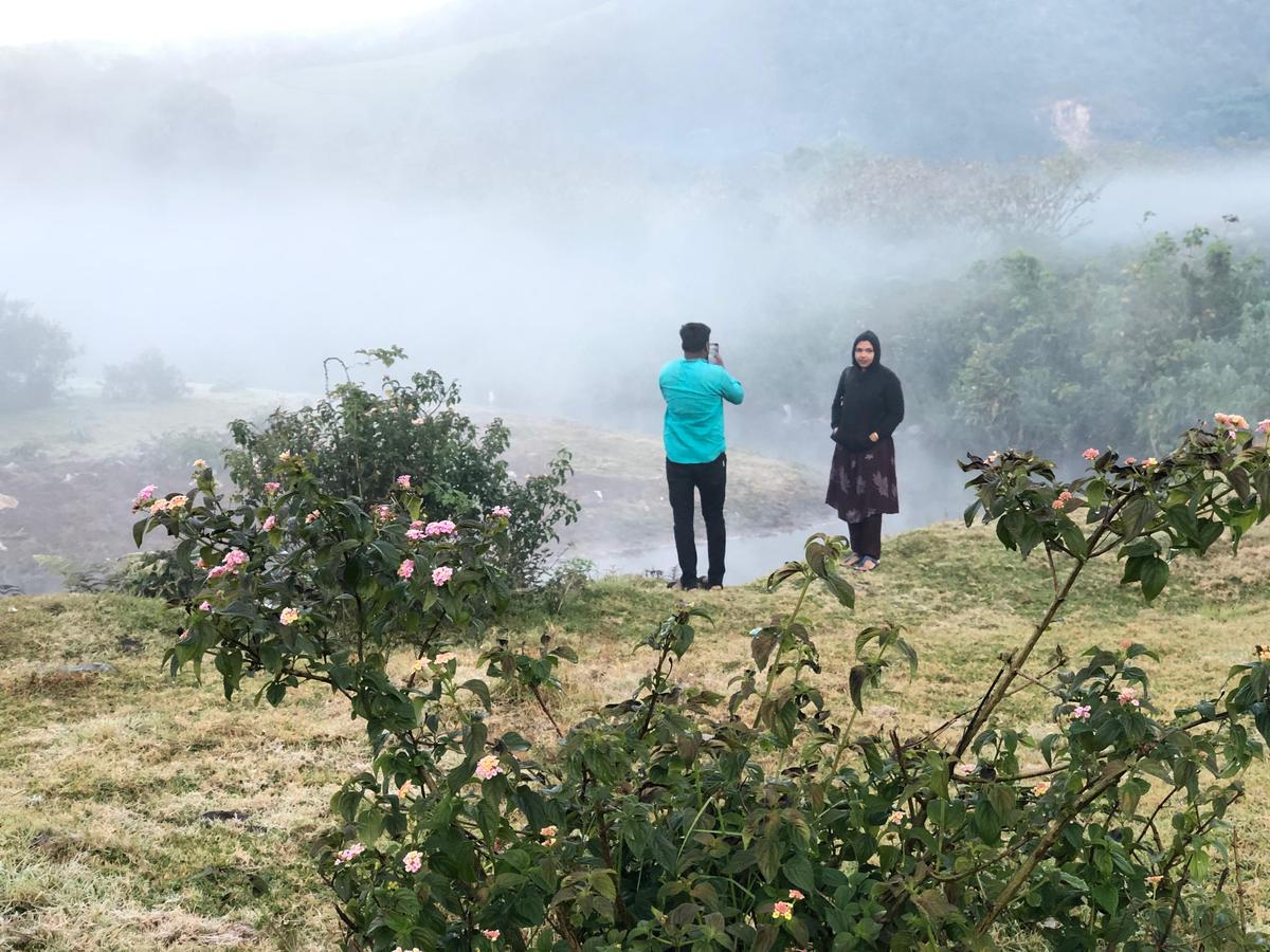 Tourists clicking pictures at Neymakkad near Munnar. 
