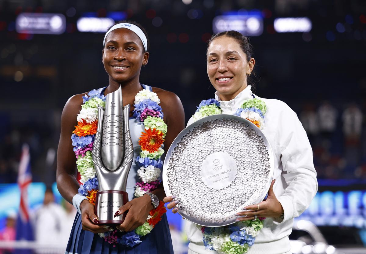 Coco Gauff of the U.S. celebrates with the trophy after winning the final, as Jessica Pegula of the U.S. poses with the runner-up trophy.
