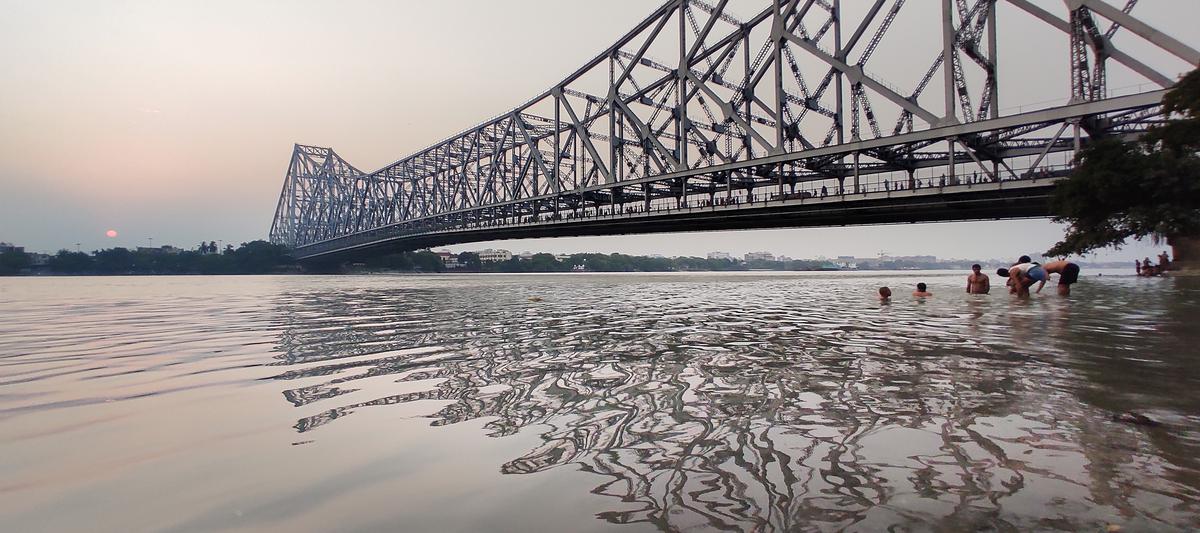 The Howrah bridge casting a shadow over the Hooghly river in Kolkata