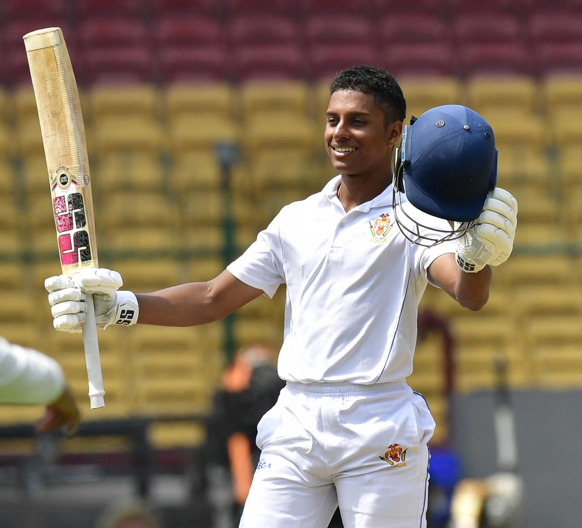 Karnataka’s K.V. Aneesh celebrates his century on day three of the Col C K Nayudu Trophy final against Uttar Pradesh at the M Chinnaswamy Stadium, in Bengaluru on March 12, 2024. 