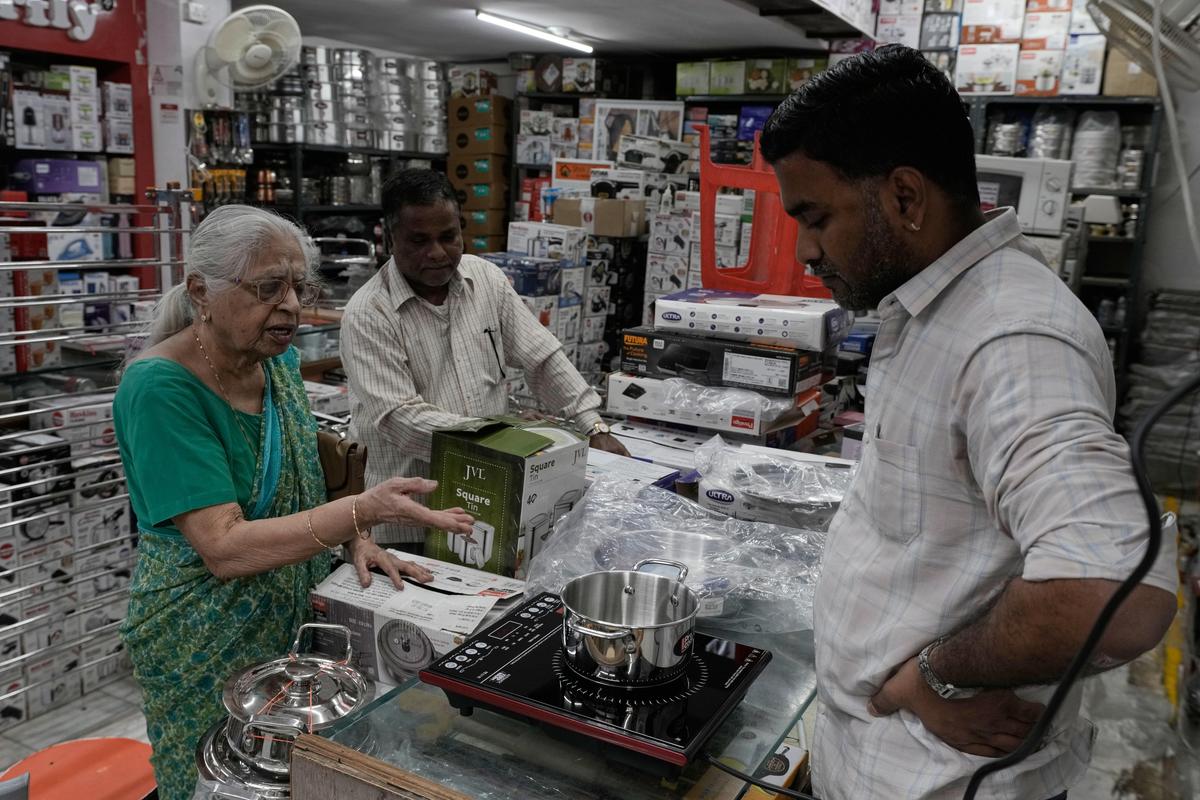 A woman shops for an induction stove at an appliance store in Hyderabad