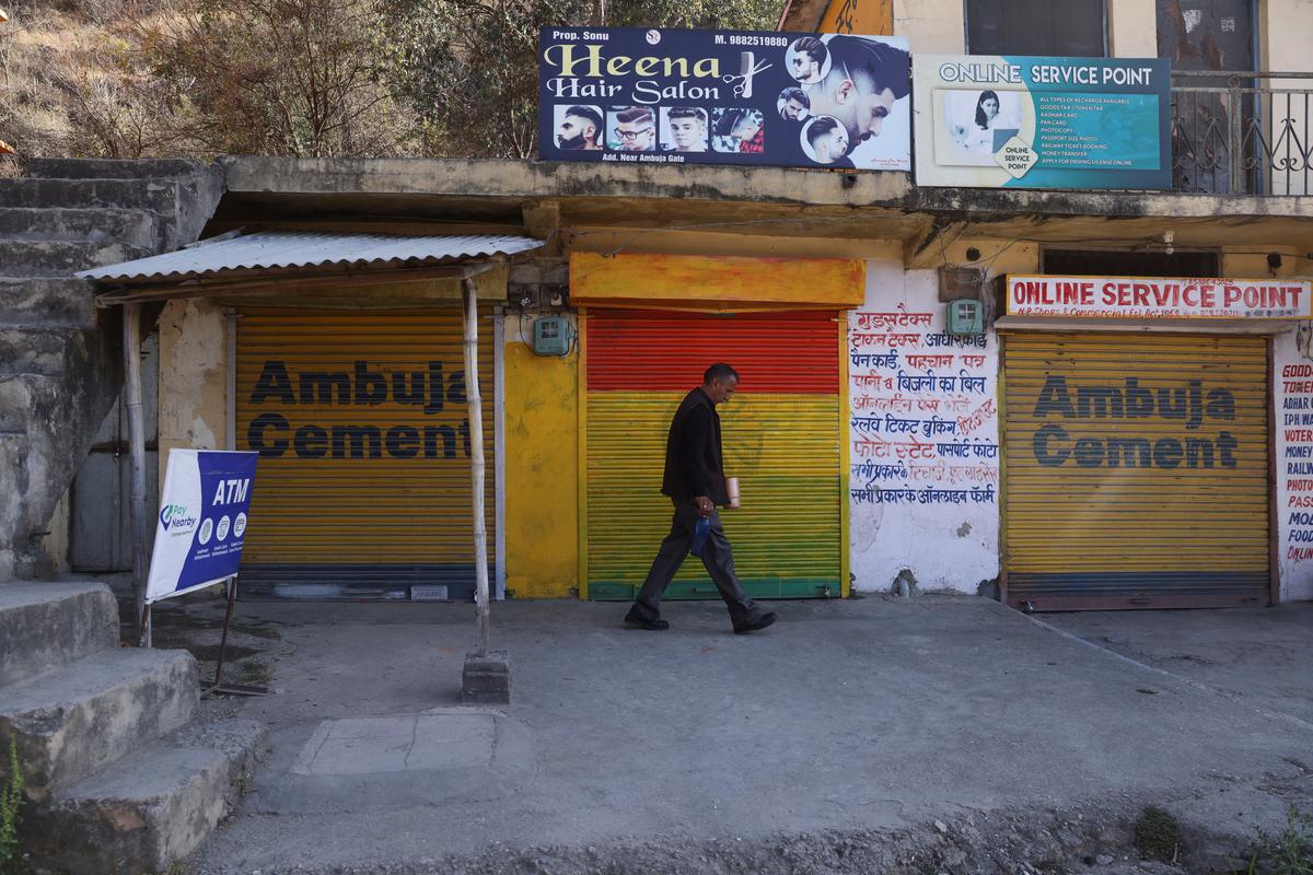 Closed shops are seen near the Ambuja Cements Limited plant owned by Adani Group in Darlaghat, Solan district, Himachal Pradesh