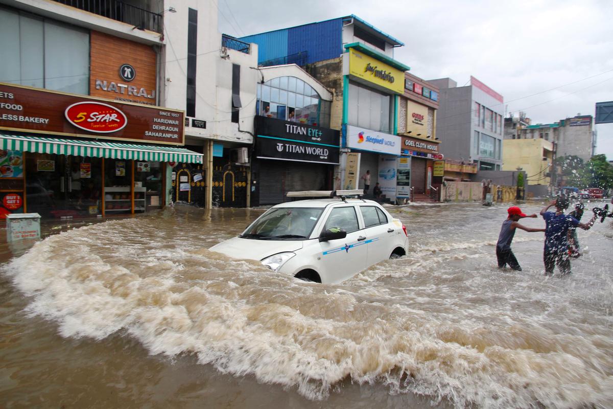 A car wades through a waterlogged road following heavy monsoon rains, in Haridwar on Tuesday, July 11