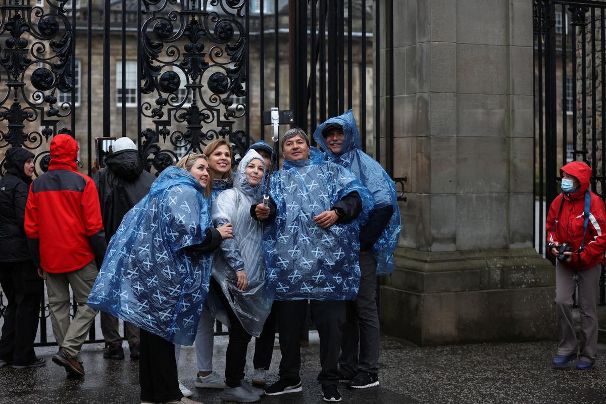 People pose for pictures outside the Palace of Holyroodhouse following a statement from the Buckingham Palace over concerns for Britain’s Queen Elizabeth’s health, in Holyrood, Edinburgh, Scotland, Britain on September 8, 2022. 