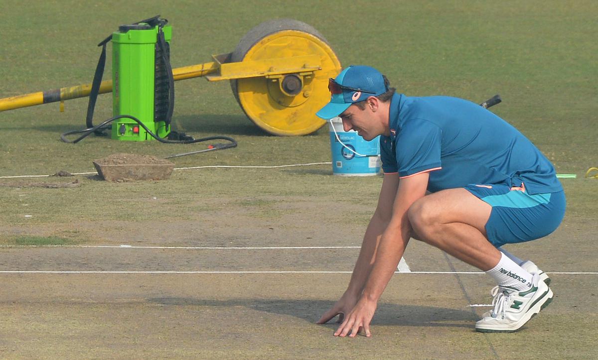 Cummins having a close scrutiny of the pitch. 