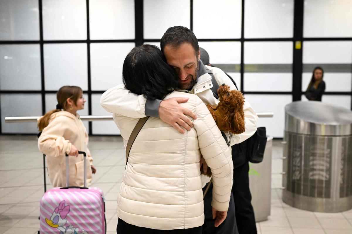 Air travelers, who were stranded in Dubai, are greeted upon arrival at Vassil Levski Internationl Airport in Sofia, Bulgaria on March 5, 2026. Thousands of flights have been delayed or cancelled in the biggest disruption to global air transport since the Covid pandemic as airlines suspend services due to the Middle East war. (Photo by Nikolay DOYCHINOV / AFP)