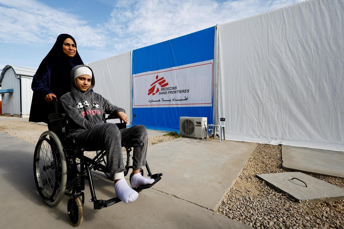 A Palestinian woman helps a burn victim, Maria Abu Aawad, at a Doctors Without Borders (MSF) hospital, amid severe shortages of medical equipment, medicines and essential materials needed for burn treatment, in Zawaida, in the central Gaza Strip, January 26, 2026. 