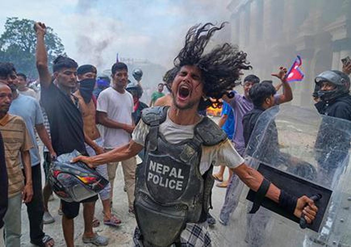 A protester wearing flak jacket and carrying a shield snatched from a policeman shouts slogans at the Singha Durbar, the seat of Nepal’s government’s various ministries and offices during a protest against social media ban and corruption in Kathmandu. A protester wearing flak jacket and carrying a shield snatched from a policeman shouts slogans at the Singha Durbar, the seat of Nepal’s government’s various ministries and offices during a protest against social media ban and corruption in Kathmandu.