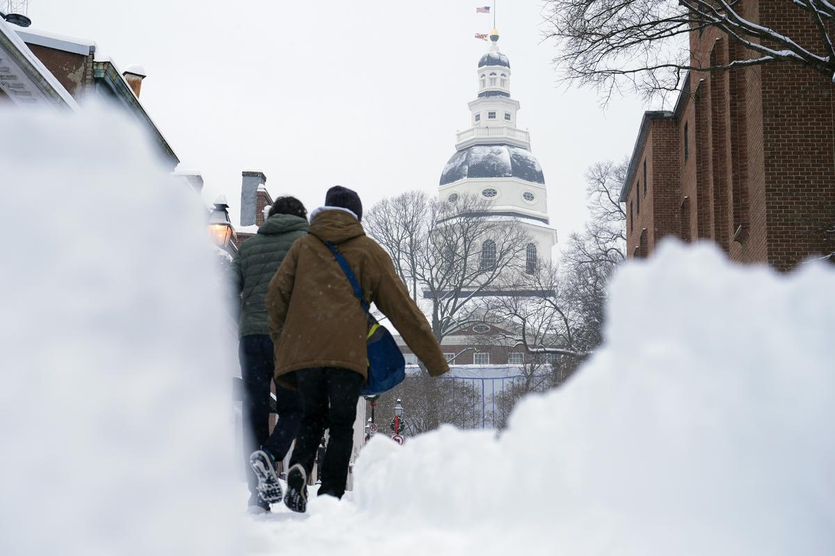 People walk the streets of Annapolis, Md., Monday, Jan. 6, 2025, during a snow storm.