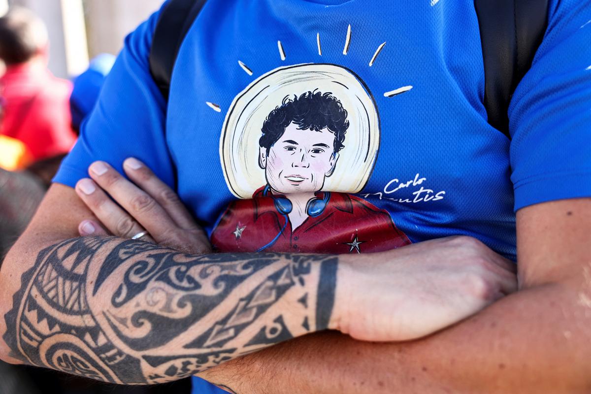 A person wears a shirt with an illustration depicting Carlo Acutis on the day Pope Leo XIV leads a Holy Mass for the canonisation of Carlo Acutis, a British-born Italian boy who will become the first millennial to be made a Catholic saint, and Pier Giorgio Frassati, in St. Peter’s Square at the Vatican, on September 7, 2025