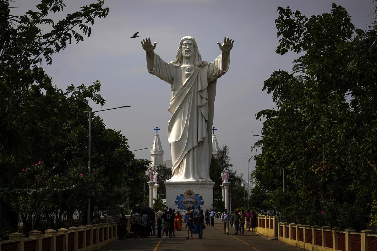 Devotees walk past a huge statue of Jesus Christ at the Basilica of Our Lady of Good Health shrine, where hundreds of visiting devotees died during 2004 Tsunami, in Velankanni, Nagapattinam, India, Sunday, December 15, 2024. 