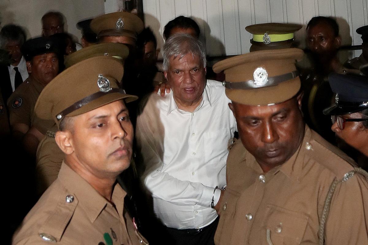Sri Lanka’s former President Ranil Wickremesinghe is escorted by prison and police officials as he leaves the Magistrate’s Court in Colombo, Sri Lanka, August 22, 2025. 