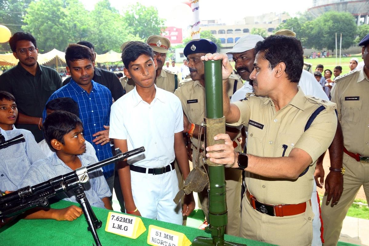 SP G. Bindhu Madhav explaining the functioning of various weapons to the students at the Open House  held as part of Police Martyrs Week, at the District Police Office at Kurnool on Saturday.