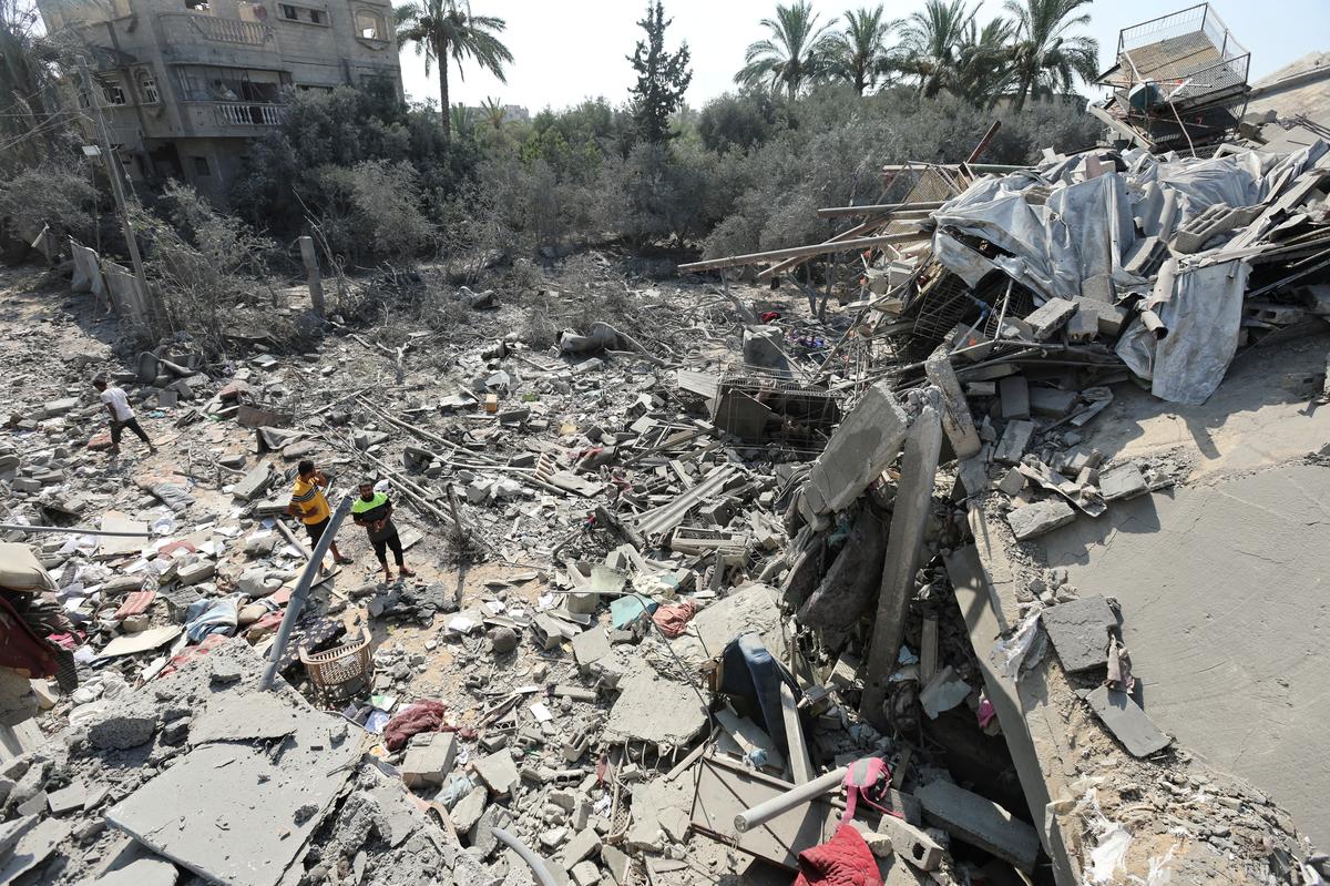 Palestinians inspect a house destroyed in an Israeli strike, amid the Israel-Hamas conflict, in Nusairat refugee camp, in the central Gaza Strip, on July 9, 2024. 