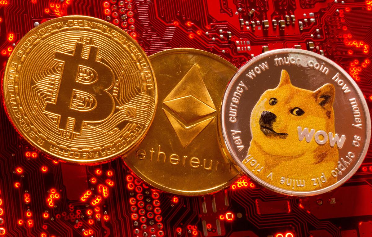 File photo of tokens representing the cryptocurrencies Bitcoin, Ether, and Dogecoin [from left to right]
