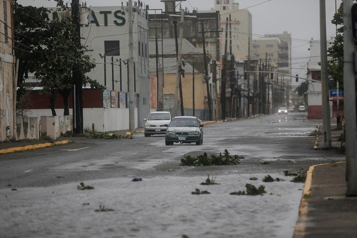 A car drives near debris on a road, as Hurricane Melissa approaches, in Kingston, Jamaica, on October 28, 2025. 