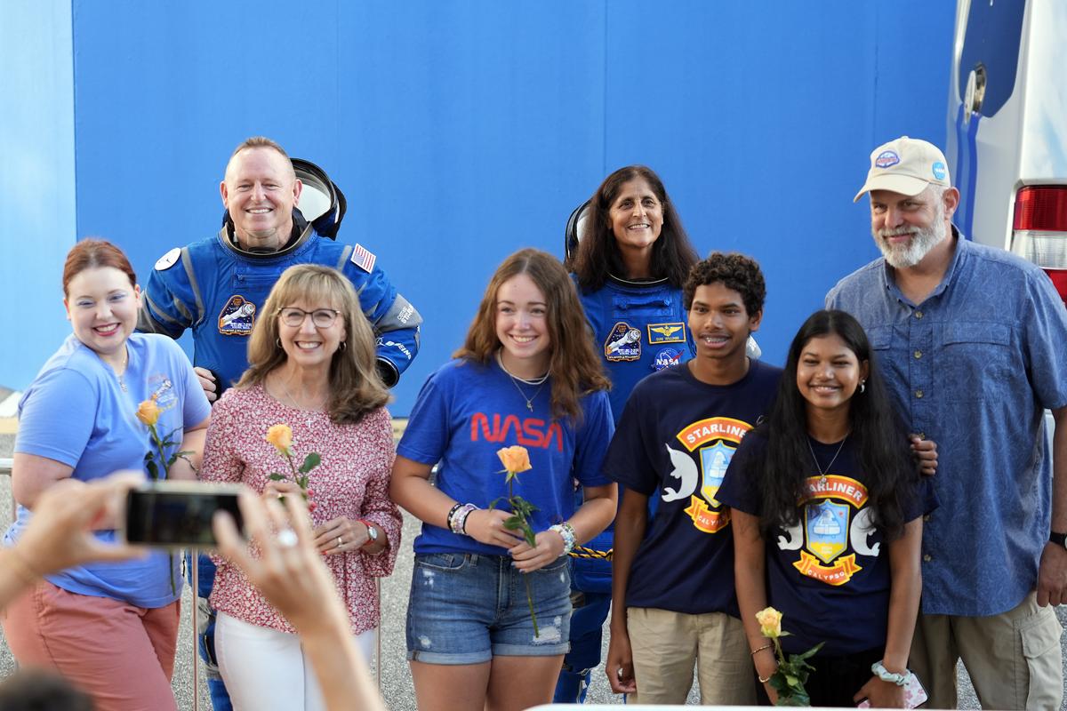 NASA astronauts Butch Wilmore, background left, and Sunita Williams, background right, pose for a photo with their families after leaving the operations and checkout building for a trip to the launch pad at Space Launch Complex 41 on June 5, 2024, in Cape Canaveral, Fla., before launching on the Boeing Starliner capsule for a trip to the international space station. 