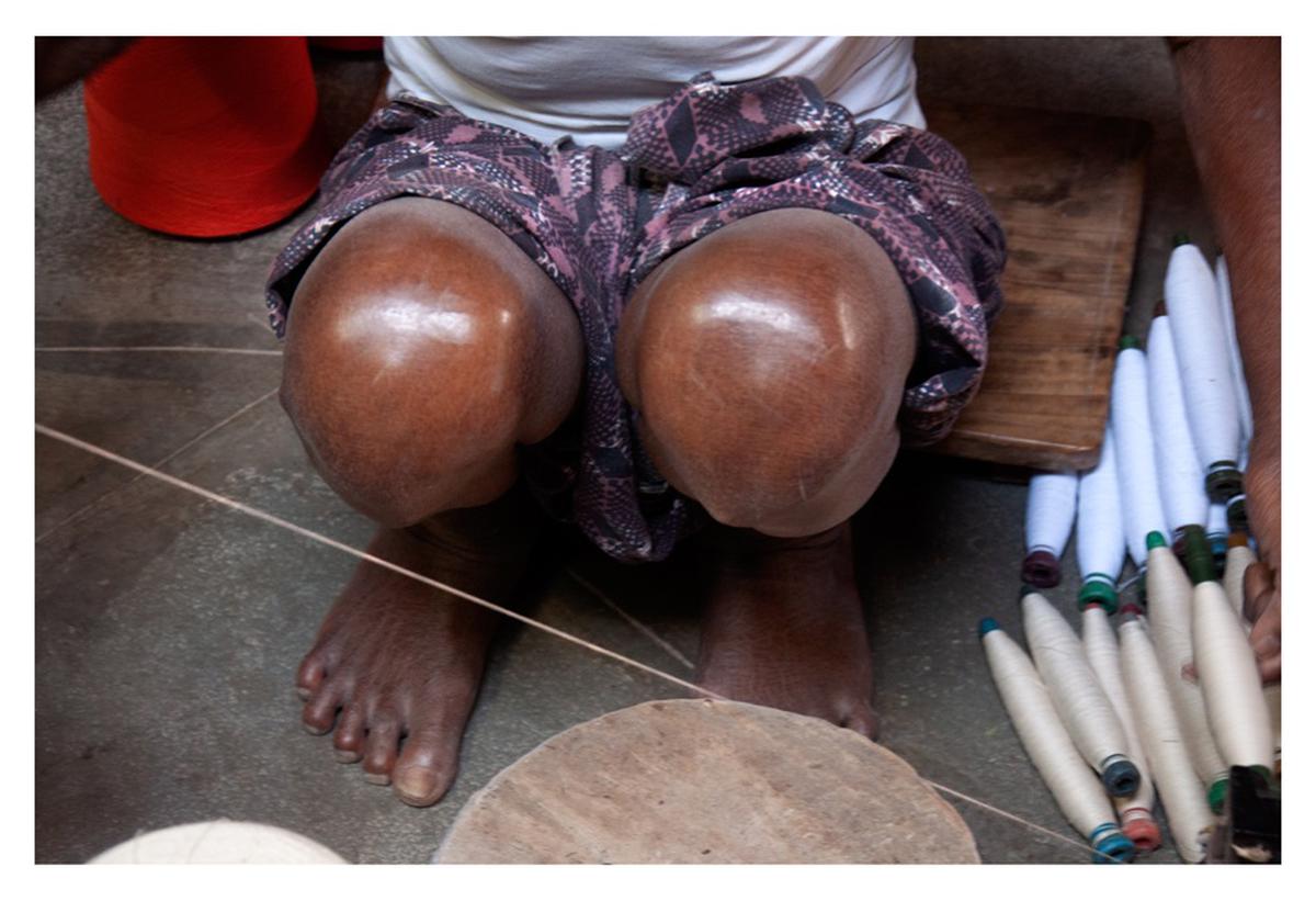 A weaver working in a sitting position by Kandukuri Ramesh Babu