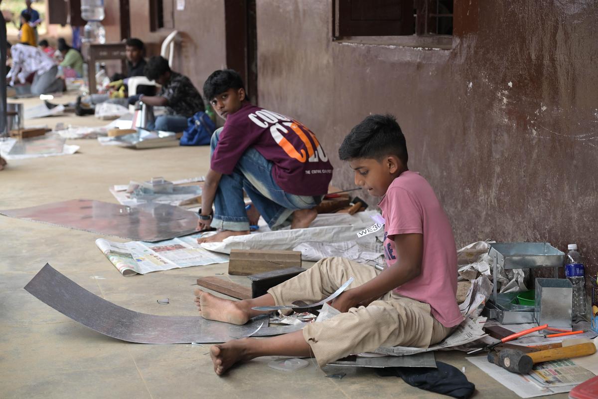 Students from various schools engaging in metal sheet works at the 57th State School Science Fair at BEMS School, Palakkad, on Sunday.
