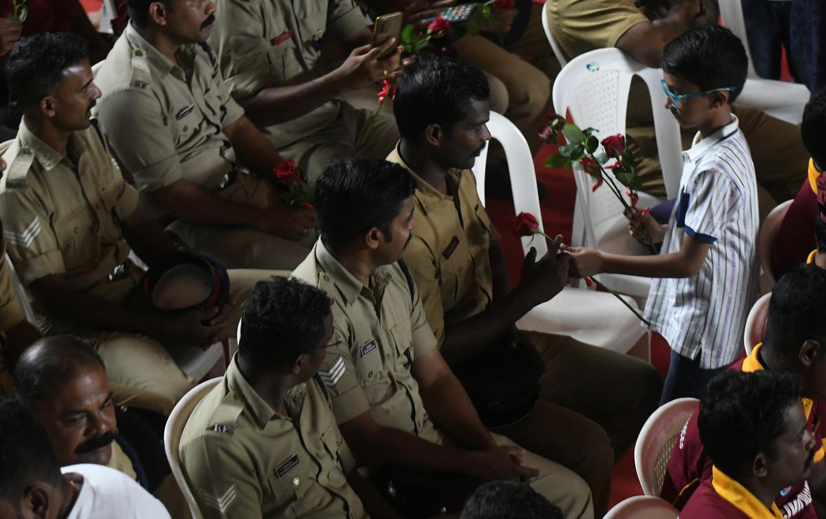 A child presents flowers to Fire and Rescue Services personnel during a felicitation event in Kochi on Wednesday. 