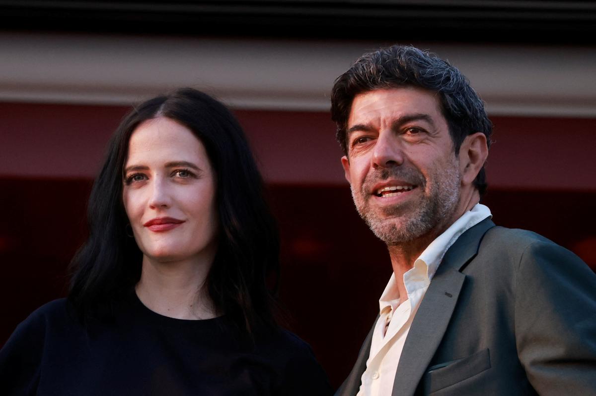 Jury members Eva Green and Pierfrancesco Favino look on from the balcony at the Hotel Martinez on the eve of the opening of the 77th Cannes Film Festival