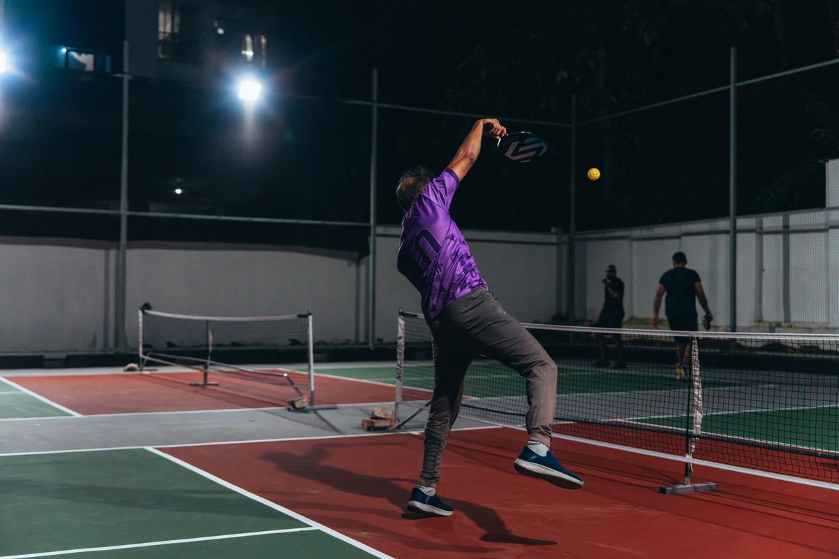 A pickleball player smashing A pickleball player smashing