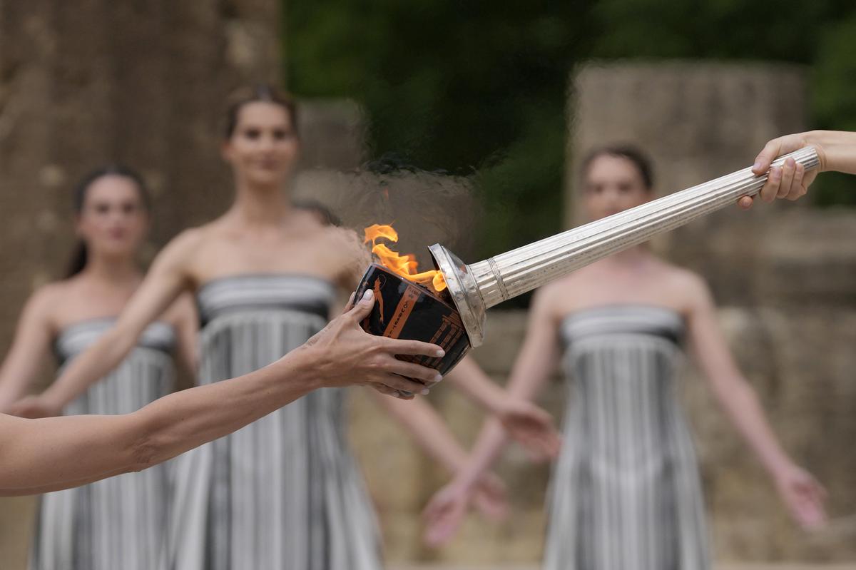 Actress Mary Mina, playing high priestess lights a torch during the official ceremony of the flame lighting for the Paris Olympics, at the Ancient Olympia site, Greece, on April 16, 2024.