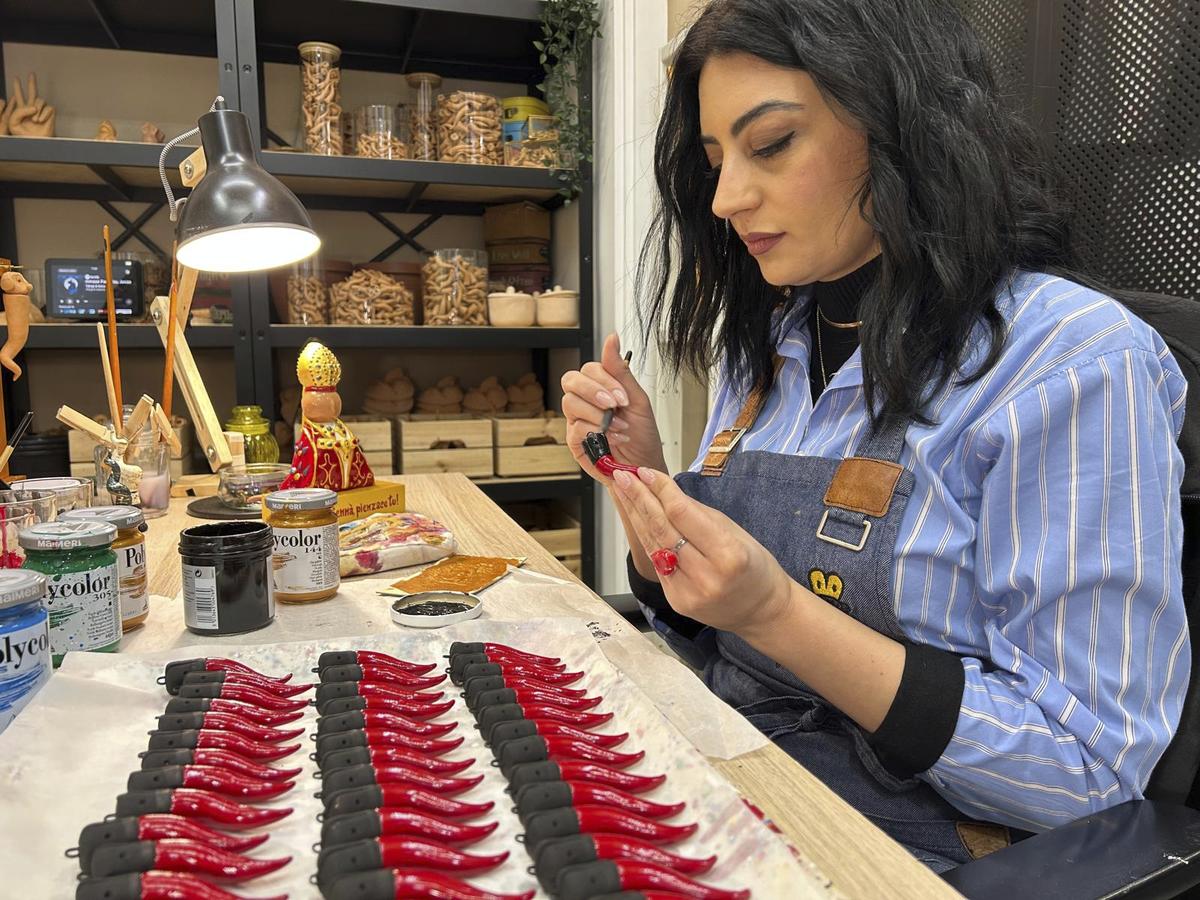 Serena D’Alessandro puts a final touch on Neapolitan horns in the family’s shop in Naples, southern Italy.