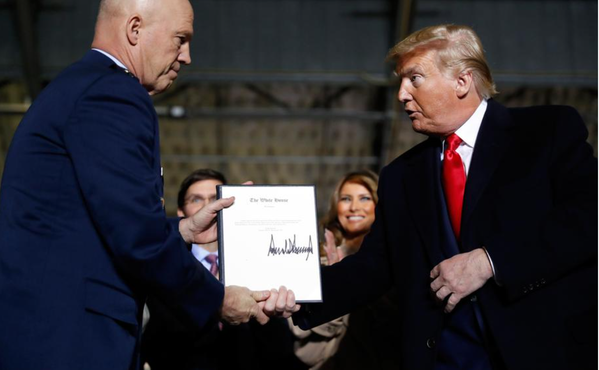 President Donald Trump shakes hands with Gen. Jay Raymond, after signing the letter of his appointment as the chief of space operations for U.S. Space Command during a signing ceremony for the National Defense Authorization Act for Fiscal Year 2020 at Andrews Air Force Base, Md., Friday, Dec. 20, 2019.