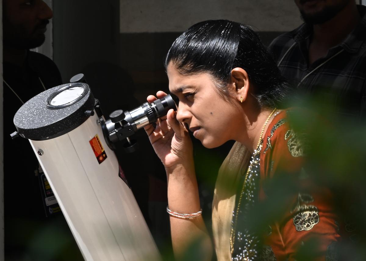 A visitor looks through a telescope kept for demonstration at the All India Science Conference held at the Tagore theatre in Thiruvananthapuram on Saturday.