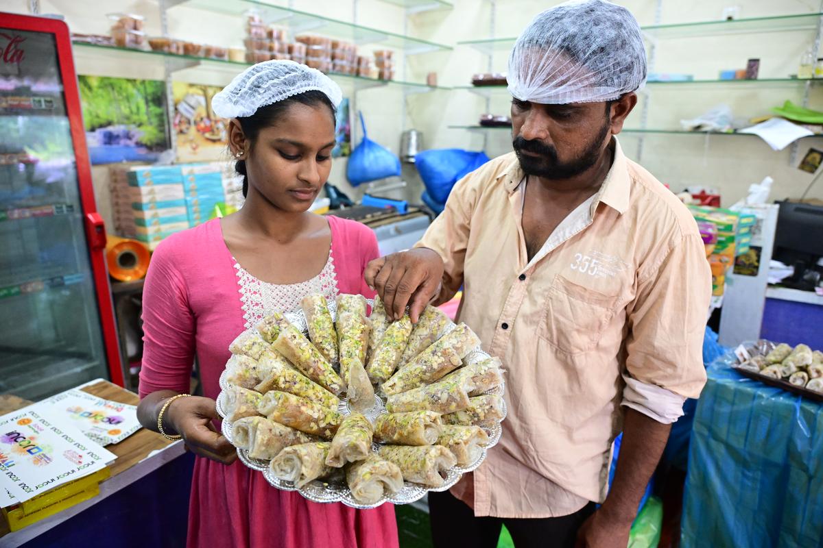 The quality of putharekulu being checked by the shopkeeper before sale at a shop in Atreyapuram in Dr. B.R. Ambedkar Konaseema district.