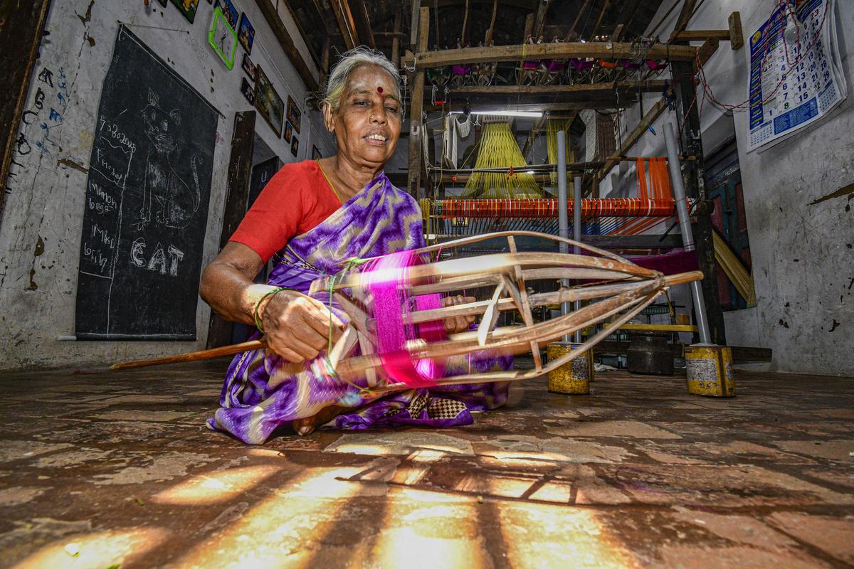 A woman prepares silk thread for weaving in a traditional handloom unit in Thirubhuvanam. 