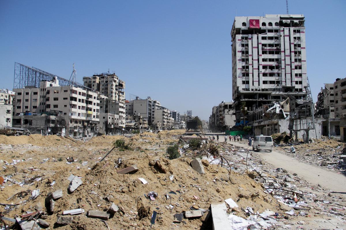 A vehicle drives near rubble during Eid al-Fitr, amid the ongoing conflict between Israel and the Palestinian Islamist group Hamas, in Gaza City on April 11, 2024. 