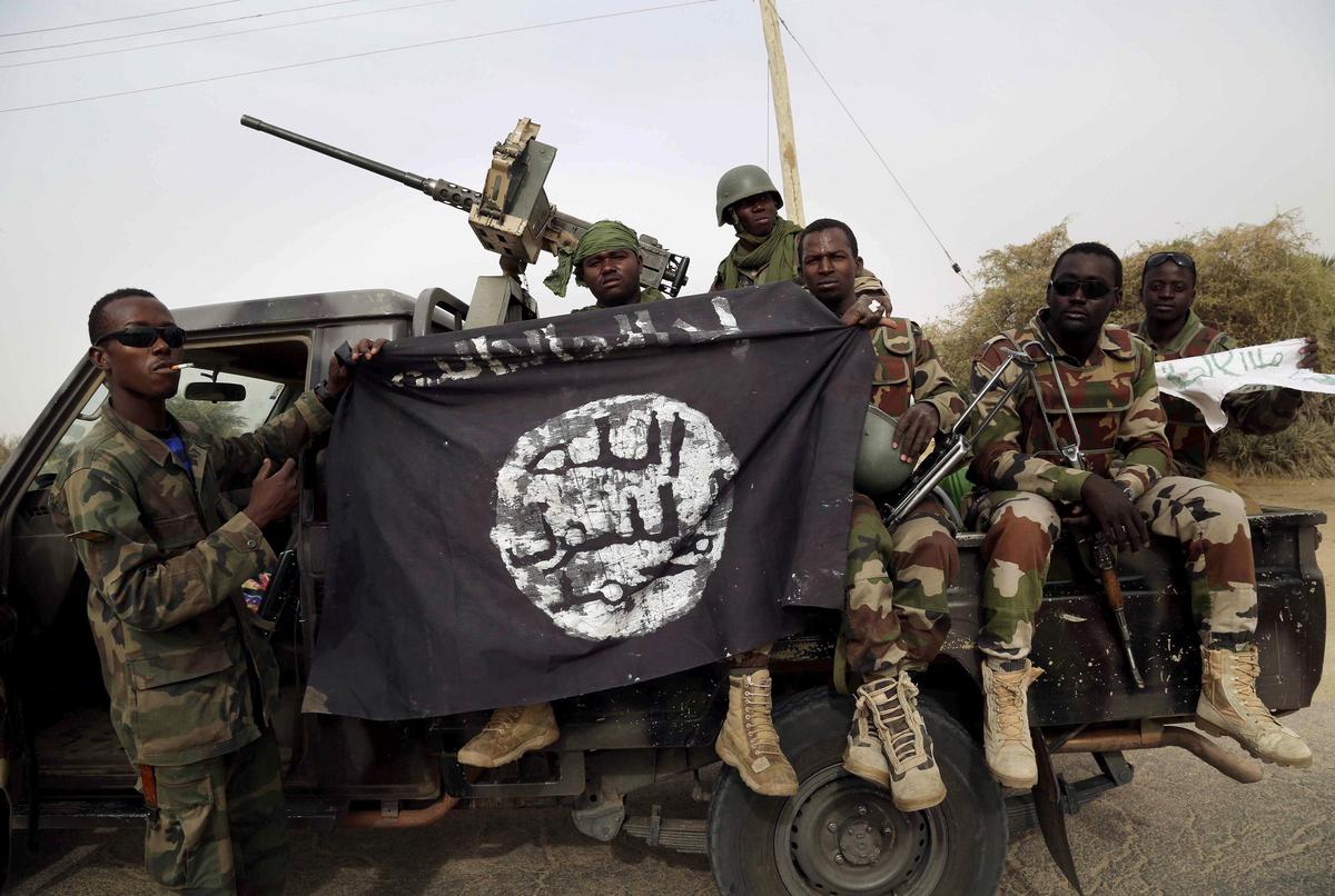 File picture of Nigerian soldiers holding up a Boko Haram flag that they seized after a raid