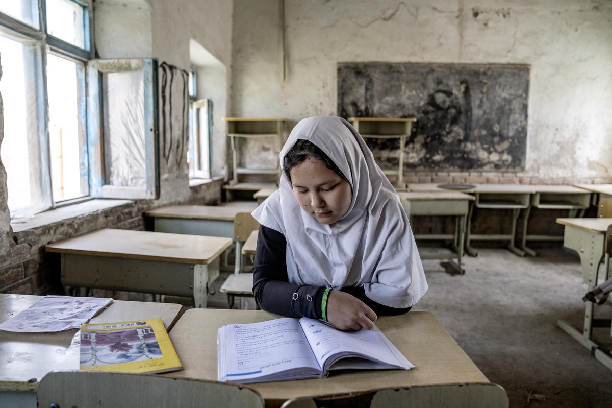 A girl reads a book in her classroom in Kabul, while thousands of schoolgirls remain barred from attending classes for the third year as the Taliban banned girls from school beyond sixth grade.