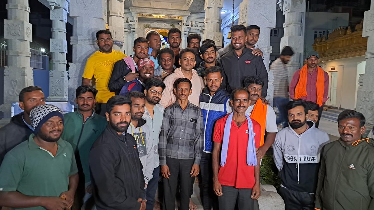 Film actor Daali Dhananjaya posing with bachelors at Venkateshwara Temple in K.M. Doddi before the bachelors took out the padayatra to M.M. Hills in February 2023.