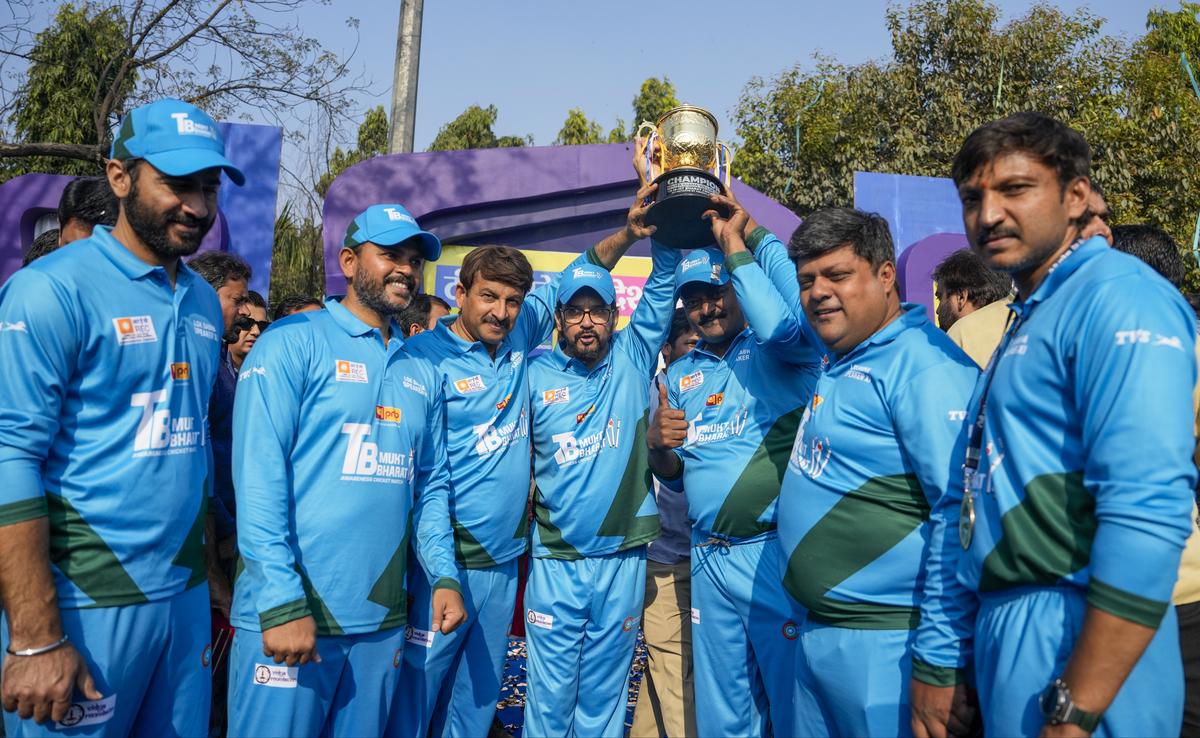 Lok Sabha Speaker XI captain Anurag Thakur (centre), along with teammates, holds the trophy after winning the cricket match.