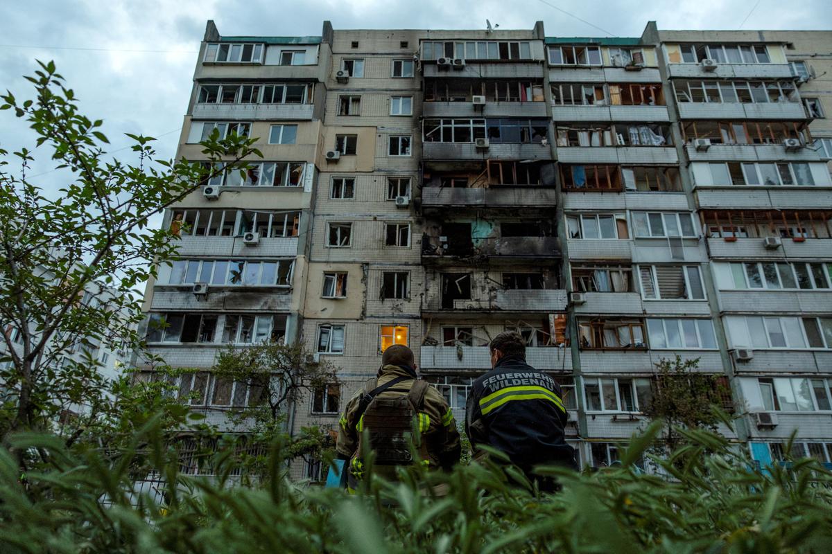 Firefighters sit outside an apartment building that was damaged during a Russian drone strike, amid Russia’s attack on Ukraine, in Kyiv, Ukraine, on May 24, 2025.