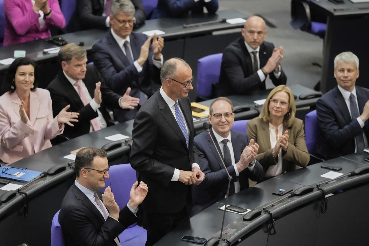 Leader of the Christian Democrats Friedrich Merz, second left, is applauded after being elected new chancellor at the German federal parliament, Bundestag, at the Reichstag building in Berlin on May 6, 2025. 