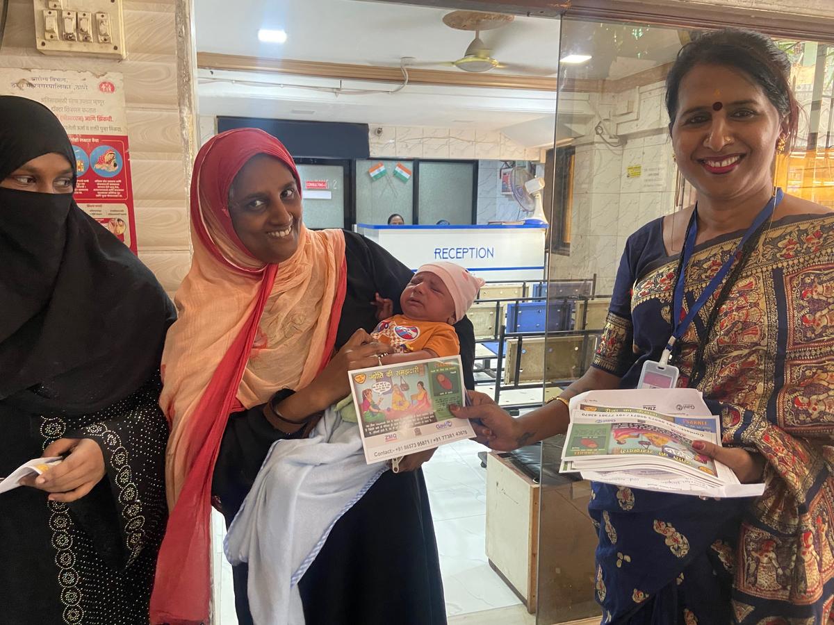 Transgender field worker Megha (far right) hands over immunisation pamphlets at a local health centre in Mumbra-Kausa.