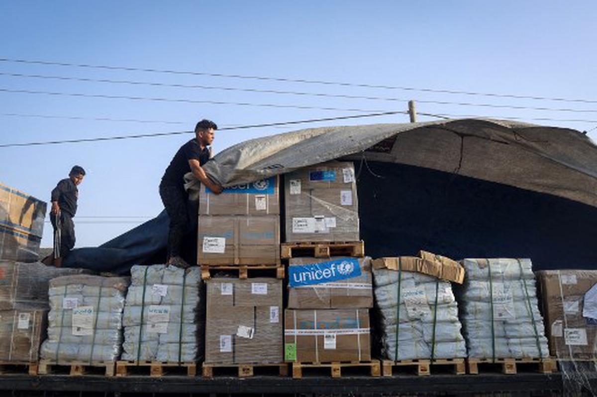 A man unloads humanitarian aid on a convoy of lorries entering the Gaza Strip from Egypt via the Rafah border crossing on October 21, 2023.