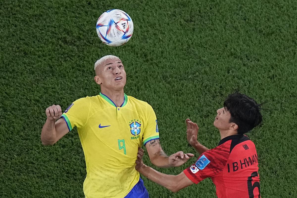 Richarlison juggles the ball on his forehead as South Korea’s Hwang In-beom looks on during the World Cup match on December 5, 2022