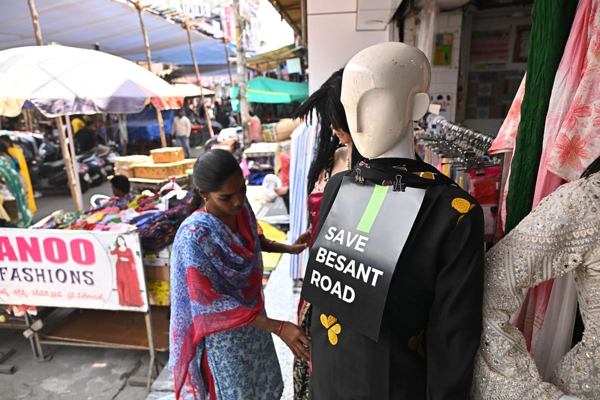 A woman adjusting a mannequin with the tag, ‘Save Besant Road’, at a shops on the Besant Road in Vijayawada.