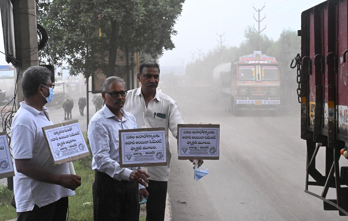 Residents holding placards against the proposed cement plant on a polluted road towards Gangavaram Port at Pedagantyada in Visakhapatnam.