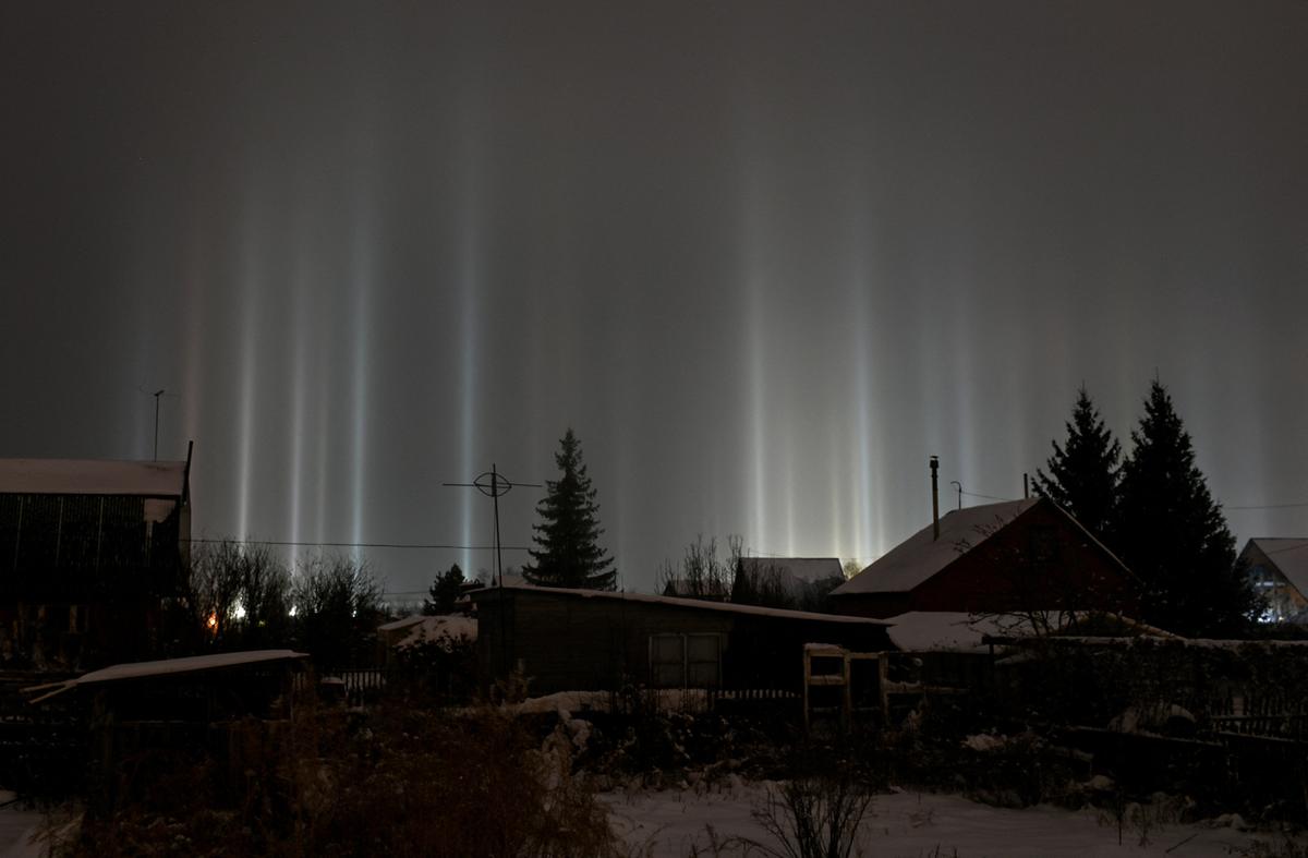 Pillars of light, which are optical atmospheric phenomena, beam up from the ground into the sky behind residential buildings in Omsk, Russia, January 2, 2023. REUTERS/Alexey Malgavko     TPX IMAGES OF THE DAY     