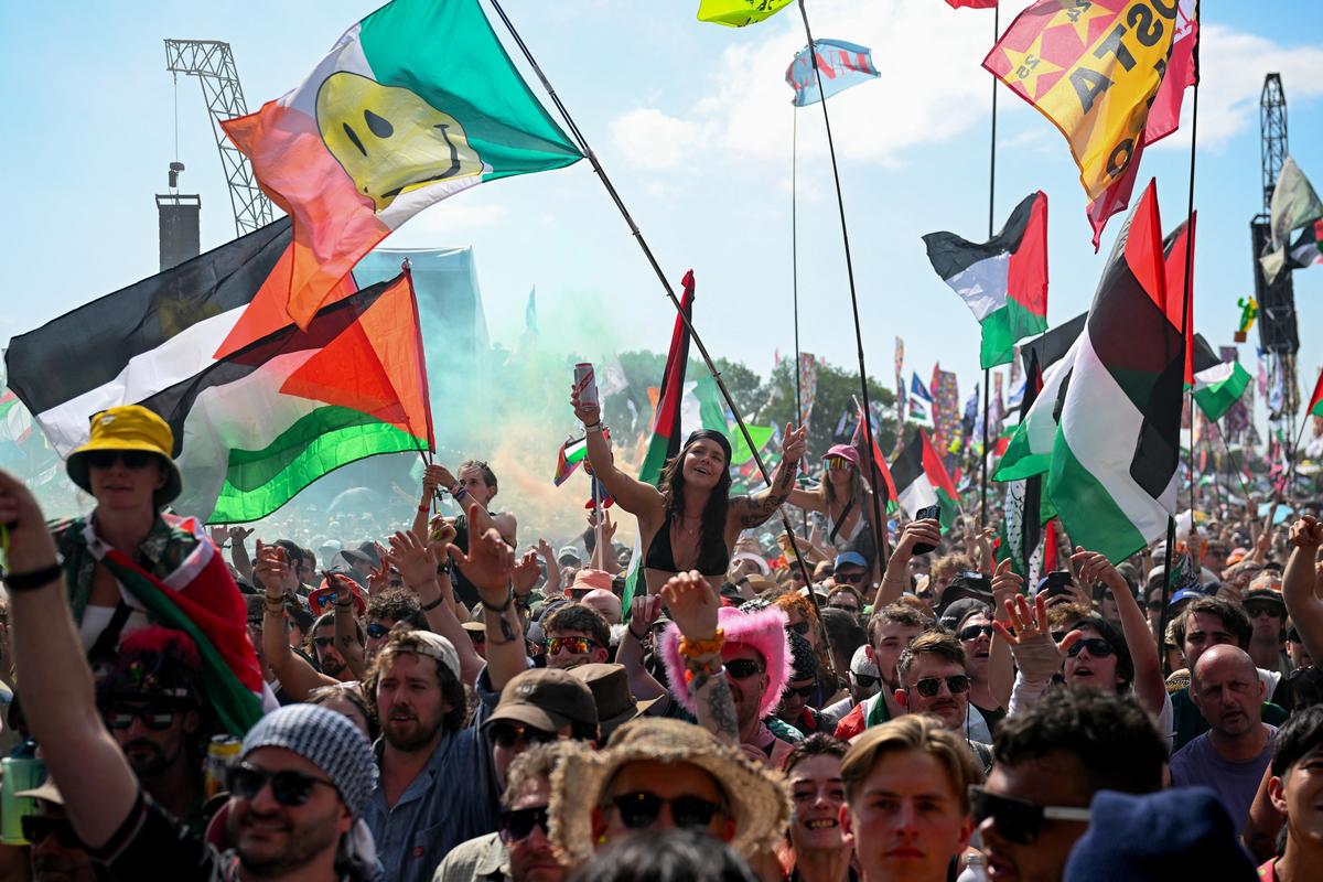 Revellers with Palestinian and other flags gather as Kneecap performs at Glastonbury Festival at Worthy Farm in Pilton, Somerset, Britain, June 28, 2025. 