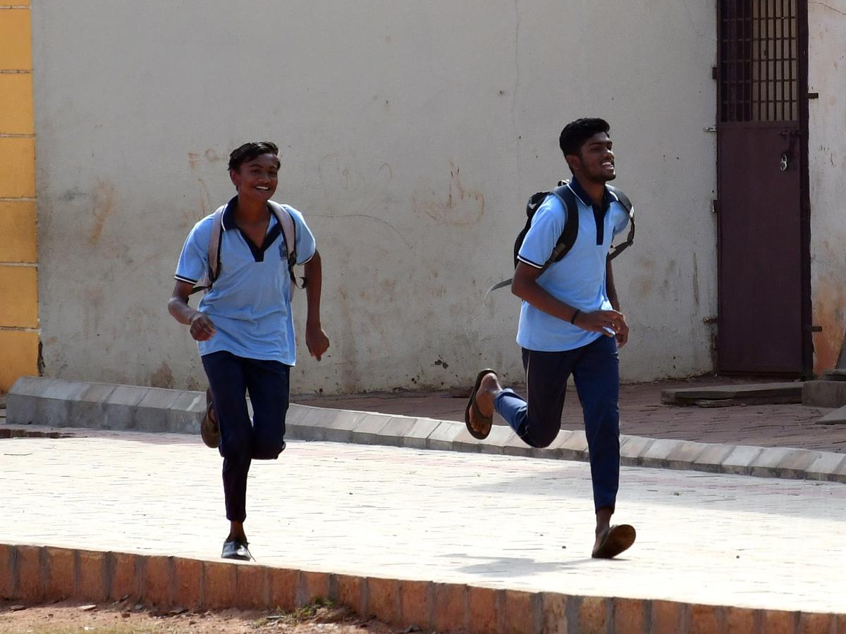 Students rushing to an SSLC examination centre in Hubballi on Friday. 